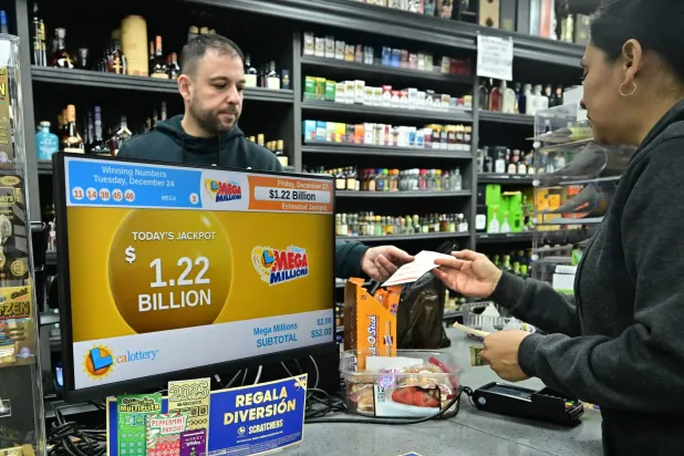 شخص يشتري تذكرة يانصيب «ميغاميليونز» من متجر الذي بيعت فيه التذكرة الفائزة بجائزة 1.22 مليار دولار (أ.ف.ب)