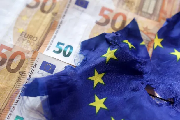 علم الاتحاد الأوروبي على عملات من فئة اليورو (رويترز)