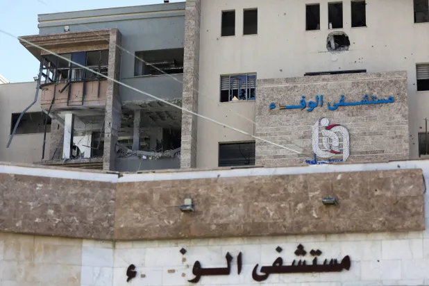 آثار قصف إسرائيلي تظهر على مبنى مستشفى الوفاء بمدينة غزة (رويترز)