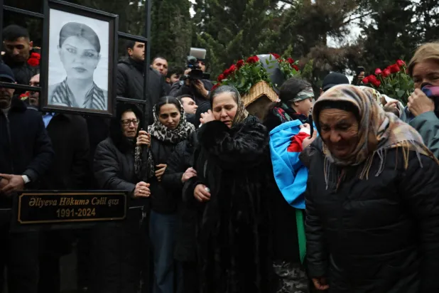 مشيِّعون يبكون خلال جنازة أحد أفراد طاقم طائرة الخطوط الجوية الأذربيجانية التي تحطمت بالقرب من مدينة أكتاو الكازاخستانية (رويترز)