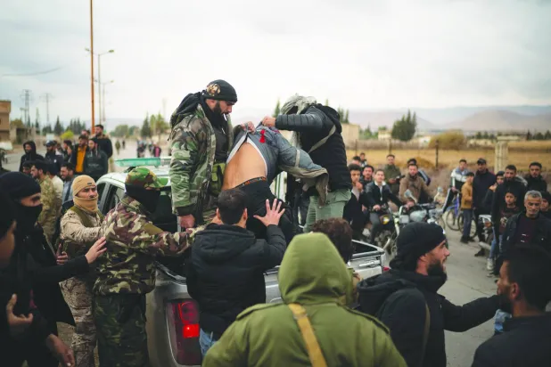 
عناصر أمن الإدارة الانتقالية السورية يعتقلون أحد المشتبه بانتمائهم لميليشيا تابعة للنظام السابق في عدرا بضواحي دمشق أمس (أ.ب)