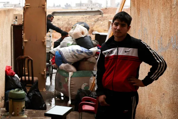 أحد أفراد أسرة ينتظر العمال لنقل ممتلكات عائلته بعد أوامر الإخلاء من فصائل «هيئة تحرير الشام» بعد الإطاحة بالرئيس السوري بشار الأسد على مشارف دمشق 29 ديسمبر 2024 (رويترز)