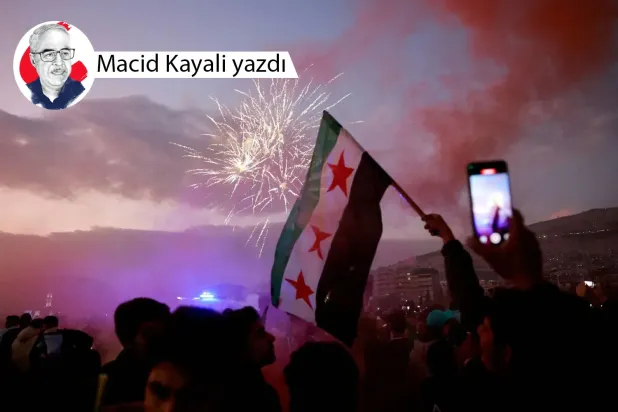 Şam'da Suriye Devlet Başkanı Beşşar Esed'in devrilmesini kutlamak için düzenlenen havai fişek gösterileri arasında muhaliflerin bayrağını dalgalandıran bir Suriyeli (Reuters)