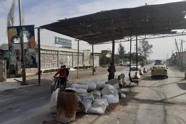 مدخل داريا الشمالي وتظهر صورة الأسد  ممزقة إلى اليسار وزُيّن الجدار بالعلم السوري الجديد (الشرق الأوسط)