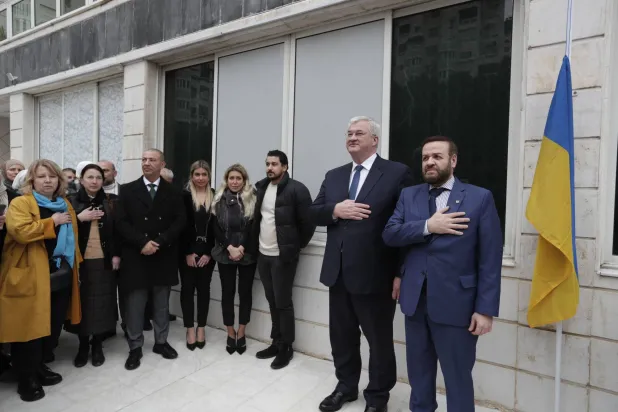 وزير الخارجية الأوكراني آندري سيبيغا (الثاني من اليمين) والقنصل الفخري العام تامر التونسي (يمين) يقفان أثناء عزف النشيد الوطني في القنصلية الأوكرانية بدمشق 30 ديسمبر 2024 (أ.ب)