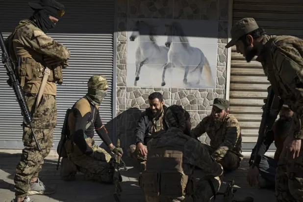 مقاتلون تابعون للإدارة السورية الجديدة في استراحة من عملية تعقب قوات شبه عسكرية تابعة للرئيس المخلوع بشار الأسد في مدينة حمص بوسط البلاد في 2 يناير (سانا - أ.ف.ب)