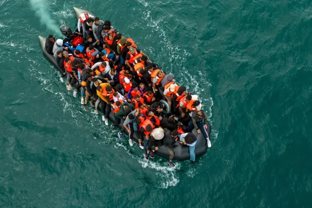 صورة ملتقطة بواسطة طائرة مسيّرة تظهر قارباً مطاطياً يحمل مهاجرين وهو يشق طريقه نحو بريطانيا في القنال الإنجليزي  6 أغسطس 2024 (رويترز)