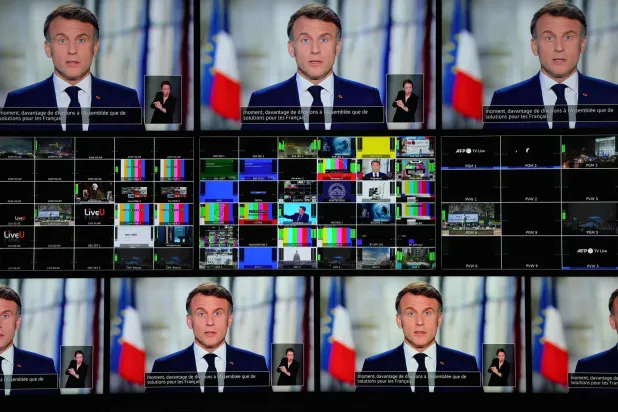 شاشات تنقل خطاب ماكرون بمناسبة السنة الجديدة في باريس (أ.ف.ب)