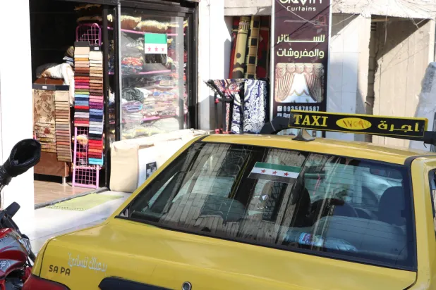 العلم السوري الجديد ينتشر على السيارات والمحلات في مزة جبل 86 بدمشق (الشرق الأوسط)