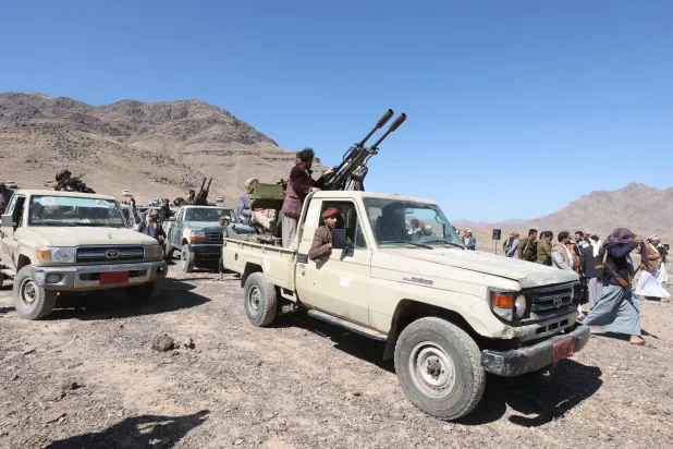 رجال قبائل مسلّحون على مركبات مزودة بمدافع رشاشة خلال تجمع مناهض لأميركا وإسرائيل لحشد مقاتلين حوثيين على مشارف صنعاء 24 ديسمبر 2024 (إ.ب.أ)