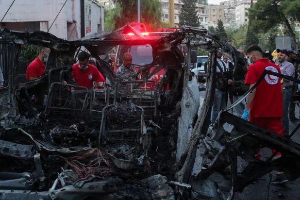 Members of the Syrian Arab Red Crescent stand near the wreckage of a car after what the Syrian state television said was a "guided missile attack" on the car in the Mazzeh area of Damascus, Syria October 21, 2024. REUTERS/Firas Makdesi 