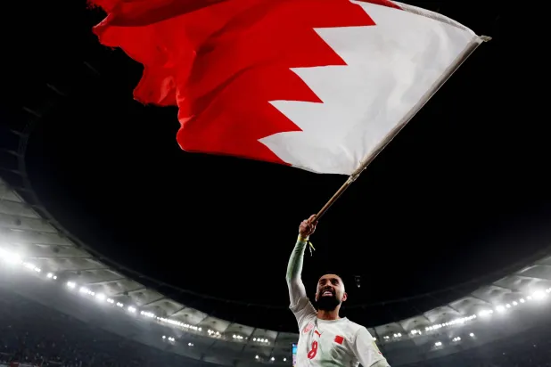 مرهون يلوح بالعلم البحريني خلال الاحتفال باللقب الخليجي (رويترز)