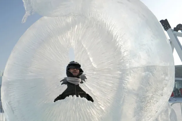 نحَّات يعمل على تمثال من جليدي في مهرجان هاربين الدولي للجليد والثلج في هاربين بمقاطعة هيلونغجيانغ بالصين 4 يناير 2025 (رويترز)