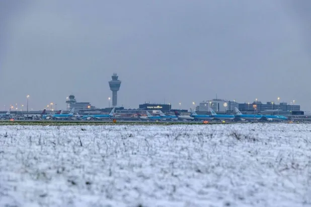 Airplanes are parked on the tarmac of Schiphol Airport during a snowfall in Amsterdam on January 5, 2025. The airport warned of delays and cancellations due to the snowfall. (ANP / AFP)  