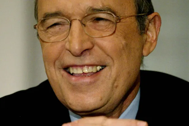FILE PHOTO: Greek Prime Minister Costas Simitis smiles to journalists during a news conference in Athens December 3, 2003. REUTERS/Yiorgos Karahalis YK/File Photo
