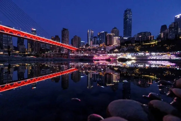 The city skyline is reflected in a pool left on the dry riverbed of the receding Jialing river, a tributary of the Yangtze, that is approaching record-low water levels during a regional drought in Chongqing, China, August 20, 2022.  (Reuters)