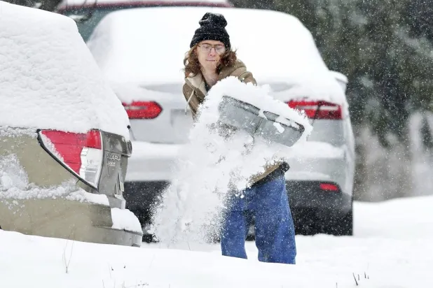 Elijah Minahan, of Johnstown, Pa., shovels out the driveway at his home in Westmont Borough as cold temperatures and snowfall hits the region on Friday, January 3, 2025. (Thomas Slusser/The Tribune-Democrat via AP)
