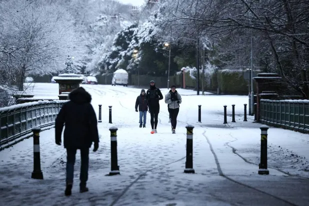 People walk in the snow at Sefton Park in Liverpool, Britain, 05 January 2025. (EPA) 