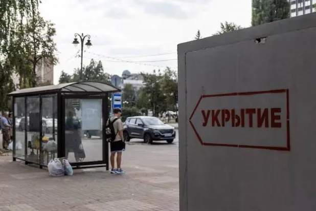 People wait at a bus stop next to a reinforced concrete bomb shelter installed in a street in the course of Russia-Ukraine conflict, in Kursk, Russia August 28, 2024. The sign on the construction reads: "Shelter". REUTERS/Maxim Shemetov/File Photo Purchase Licensing Rights