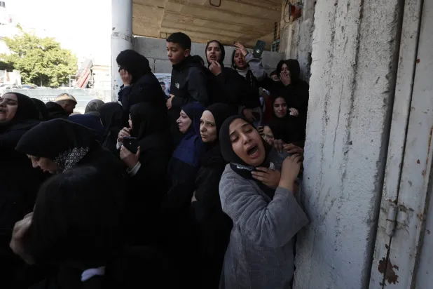 أقارب شاب فلسطيني قتل علي يد الجيش الإسرائيلي خلال جنازته في مخيم بلاطة بالضفة الغربية (إ.ب.أ)