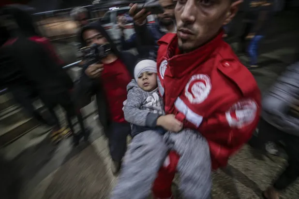 نقل طفل فلسطيني مصاب إلى مستشفى الأقصى في أعقاب غارة جوية إسرائيلية على مخيم البريج للاجئين في دير البلح (إ.ب.أ)