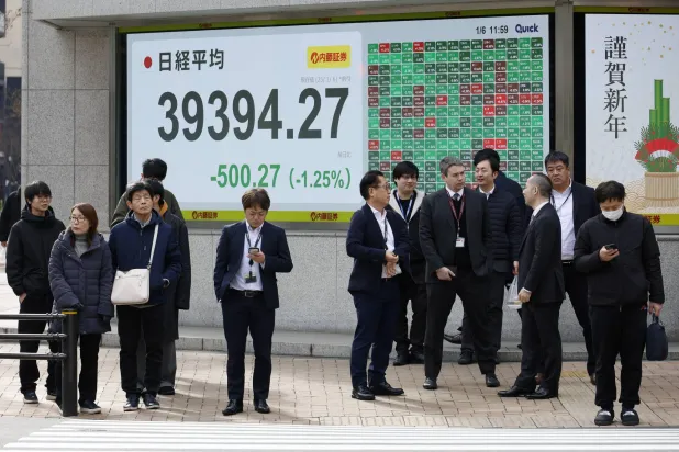 مارة يقفون أمام لوحة مؤشر سوق الأسهم في طوكيو (وكالة حماية البيئة)