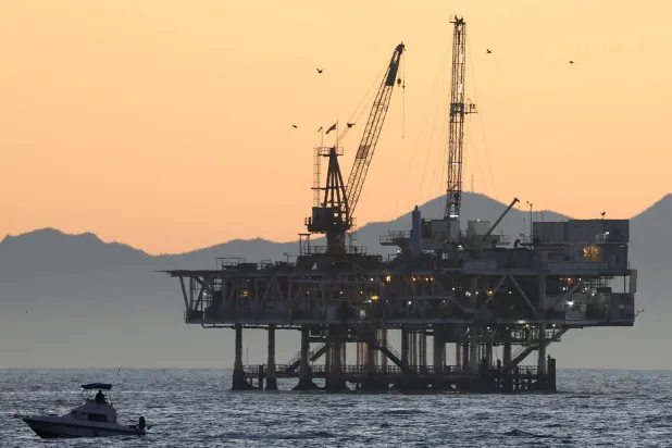 قارب صغير أمام منصة النفط والغاز البحرية «إستير» بالمحيط الهادئ في كاليفورنيا (أ.ف.ب)