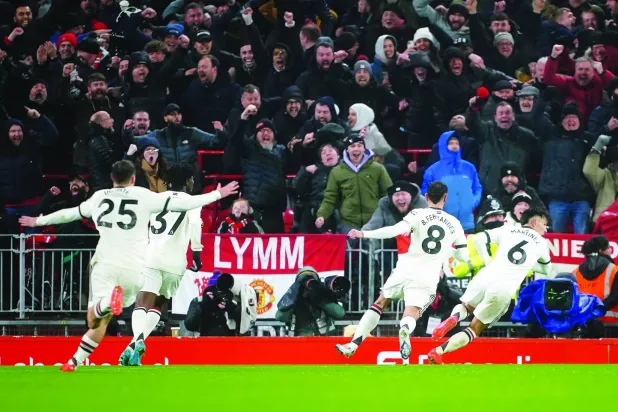 لاعبو يونايتد يحتفلون بعد هدف مارتينيز الأول في لقاء التعادل المثير بملعب أنفيلد (د.ب.أ)