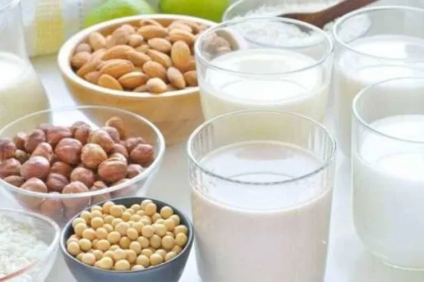 أكواب من الحليب النباتي بجانب المكسرات (أرشيفية - إ.ب.أ)