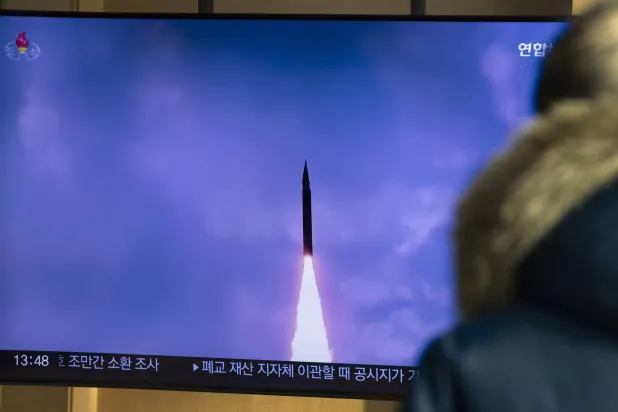مواطن من كوريا الجنوبية يشاهد لحظة إطلاق بيونغ يانغ صاروخاً باليستياً فرط صوتي جديداً متوسط المدى (إ.ب.أ)