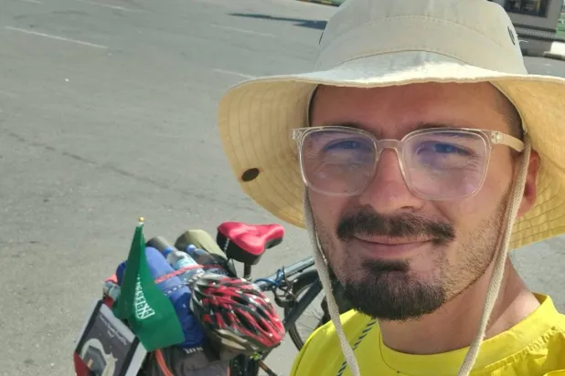 سيكي هوتي مع دراجته التي قطع بها مسافة 6800 كيلومتر من كوسوفو إلى مكة المكرمة (الشرق الأوسط)