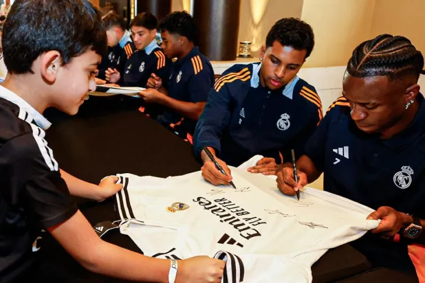 لاعبو الريال يوقعون على قميص أحد الأطفال في مقر اقامتهم بجدة (نادي ريال مدريد)