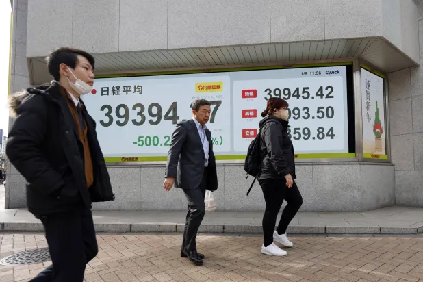 يمر المشاة أمام لوحة مؤشر سوق الأوراق المالية في طوكيو (وكالة حماية البيئة)