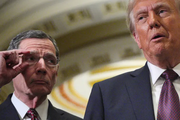 ترمب يتحدث وبجانبه السيناتور الجمهوري جون باراسو بعد اجتماع مع المشرعين الجمهوريين بمبنى الكابيتول في 8 يناير (رويترز)