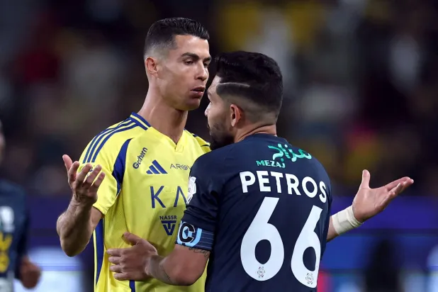 بيتروس يحاول تهدئة رونالدو بعد مشادة مع أحد لاعبي الأخدود (رويترز)