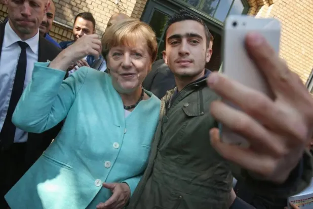 Former German Chancellor Angela Merkel and Anas Modamani, one of Germany’s most well-known Syrian refugees (Getty Images)