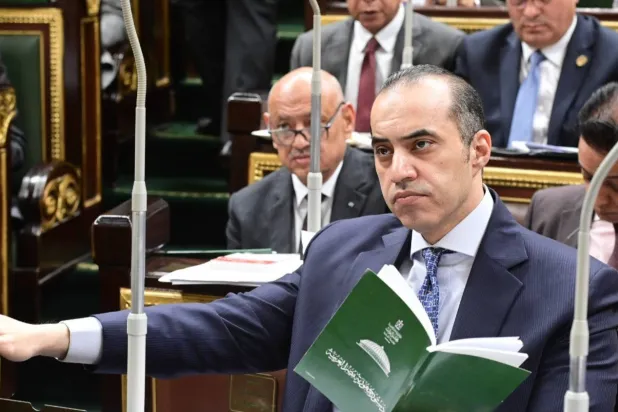 وزير الشؤون النيابية المصري ممسكاً بالدستور خلال مناقشة مشروع قانون الإجراءات الجنائية بمجلس النواب (مجلس الوزراء)