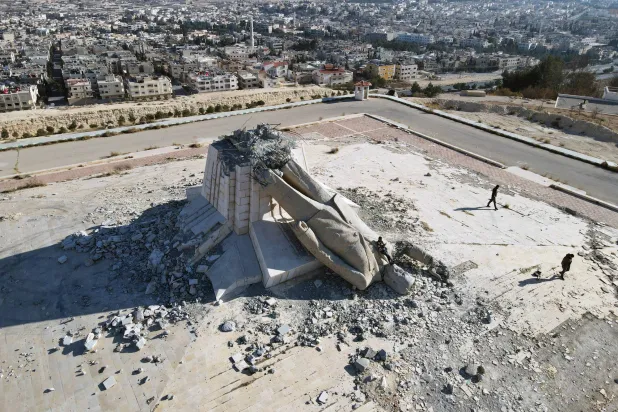 لقطة جوية تُظهر تمثال الرئيس السوري السابق حافظ الأسد ملقى على الأرض في بلدة دير عطية بالقلمون (إ.ب.أ)