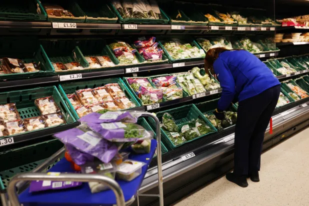 عامل يفرز البضائع بأحد المتاجر الكبرى في لندن (إ.ب.أ)