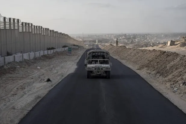 عربة عسكرية إسرائيلية تسير على طريق تم «تزفيته» في ممر فيلادلفيا (أرشيفية - د.ب.أ)