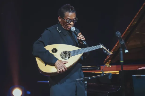 هانكوك مُمسكاً بالعود على الطريقة السعودية ومتحدّثاً لجمهور حفل الرياض (الشرق الأوسط)