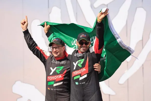  Saudi driver Yazeed al-Rajhi (R) and co-driver Edouard Boulanger (L) celebrate after winning the Dakar Rally 2025 in the car category at the end of the 12th and last stage in Shubaytah, on January 17, 2025. (AFP) 