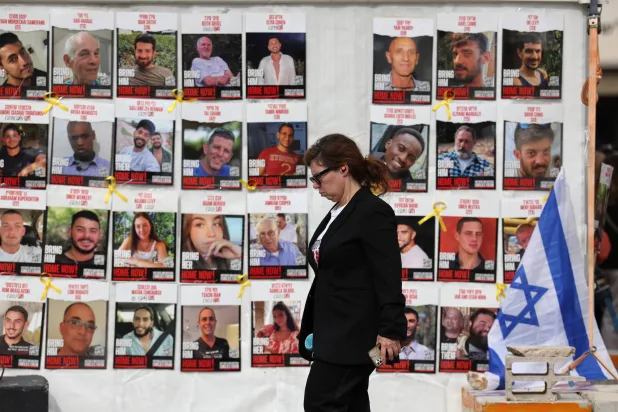 صور رهائن إسرائيليين في غزة على جدار أمام مقر القيادة العسكرية الإسرائيلية في تل أبيب الجمعة (إ.ب.أ)