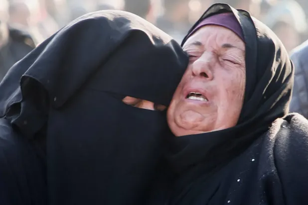  İsrail hava saldırısı sonucu hayatını kaybedenlerden birinin yakınları, dün Han Yunus'taki Nasır Hastanesi'nde (Reuters)