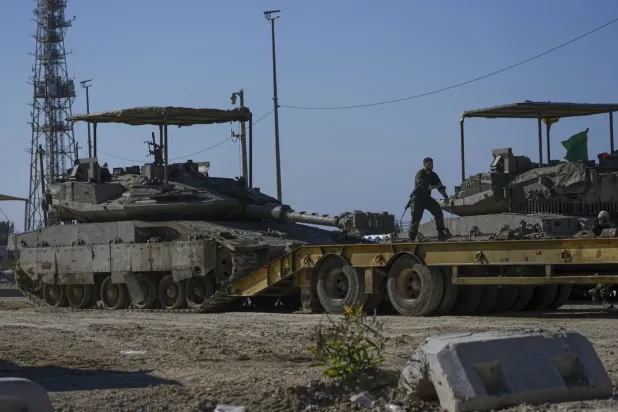 İsrail askerleri dün Gazze Şeridi sınırında bir nakliye kamyonuna tank yükledi (AP)