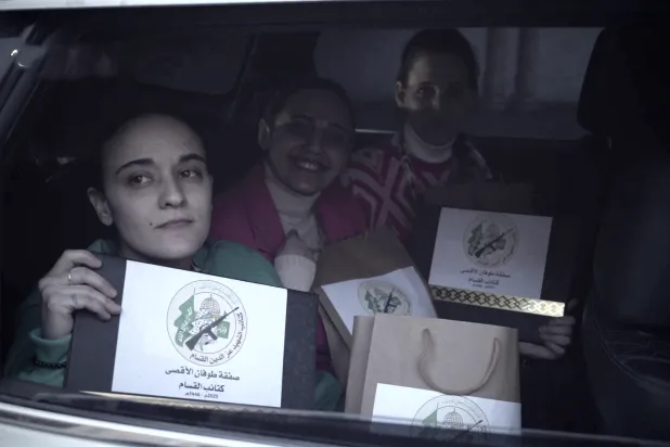 الرهائن الثلاث يحملن «قرار الإفراج عن أسير» قبل الإفراج عنهن من غزة (لقطة من فيديو لـ«كتائب القسام»)