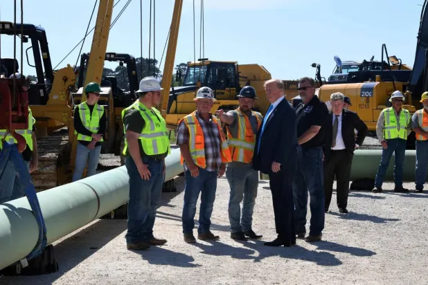 الرئيس ترمب خلال حديثه مع بعض المهندسين في موقع عمليات حفر في ولاية تكساس (أ.ف.ب)