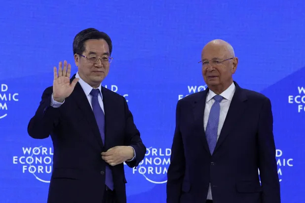 دينغ برفقة مؤسس منتدى «دافوس» قبل إلقائه كلمته... 21 يناير (رويترز)