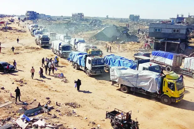 Dün Gazze Şeridi'nin güneyindeki Refah Sınır Kapısı’ndan geçen yardım kamyonlarına doğru koşan Filistinliler (Reuters)