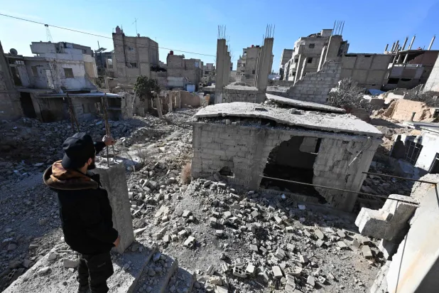 رجل ينظر إلى منزله المدمر في حمورية بمنطقة الغوطة الشرقية (أ.ف.ب)